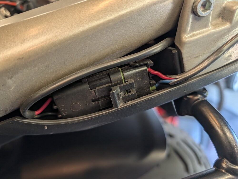 Two-wire top-case lighting connector installed beneath the rear bodywork
