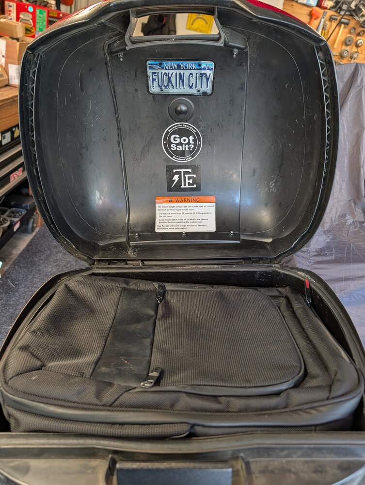 Open Buell top case showing the wire routed through the lid and hinge area